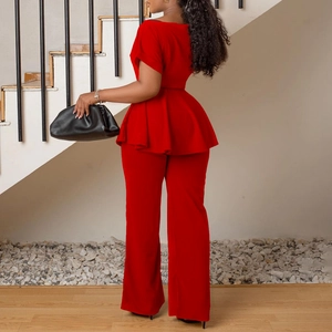 Détail du haut à basque rouge et du pantalon large à taille haute en tissu éclatant