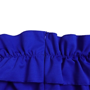 Détail de la robe bleu roi montrant le design à volants et la fermeture éclair invisible
