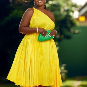 Detail of a bright yellow one-shoulder pleated maxi dress with elegant draped fabric texture