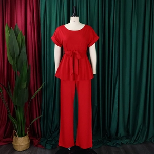 Détail d'un ensemble rouge deux pièces avec haut à volants noué et pantalon large taille haute