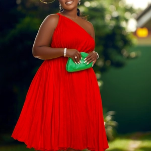 Detail of red pleated one-shoulder dress showing textured fabric and elegant A-line drape