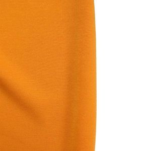 Close-up detail of the orange knitted fabric texture and elastic material of the dress