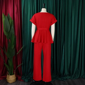 Vue arrière de l'ensemble rouge deux pièces avec haut à basque et pantalon jambe droite