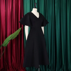 Detail of elegant black V-neck evening dress with ruffle sleeves on display stand