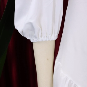 Dettaglio di maniche a sbuffo bianche con polsini elastici e texture in tessuto plissettato