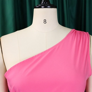 Detail of rose pink one-shoulder dress showing elegant fabric pleats on the shoulder