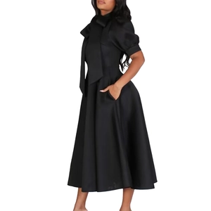 Détail de la robe noire élégante avec manches bouffantes et grand nœud à l'encolure