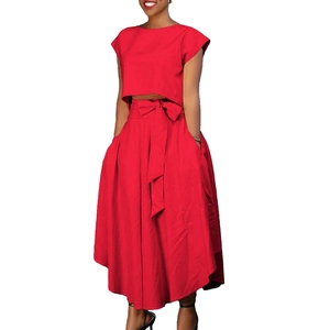 Detail of red two-piece set featuring short crop top and high waist maxi skirt with bow
