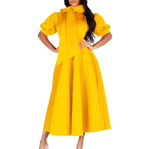 Détail d'une robe longue jaune avec col haut, gros nœud et manches bouffantes