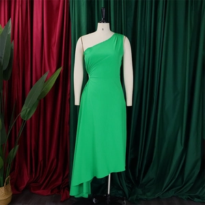 Detail of green one-shoulder dress showing side ruching and asymmetrical hem on a mannequin