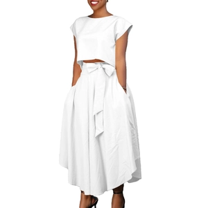 Detail of white two-piece set featuring crop top and high-waist skirt with bow tie