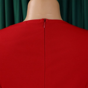 Detail of red dress neckline featuring a hidden zipper and textured knit fabric
