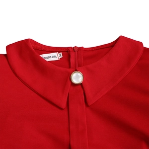 Detail of red Peter Pan collar with a gold-rimmed pearl button and invisible zipper