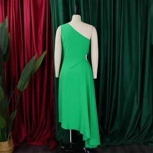 Detail view of the side cutout and asymmetrical hem on this vibrant green one-shoulder dress