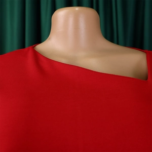 Detail of red asymmetrical neckline and smooth fabric texture on fashion dress