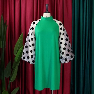 Detail eines grünen Kleides mit weißen Mesh-Laternenärmeln und schwarzen Polka Dots