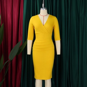 Detail of yellow V-neck pencil dress featuring elegant waist pleats and slim fit silhouette