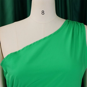 Close-up of bright green one-shoulder dress with elegant pleated shoulder details