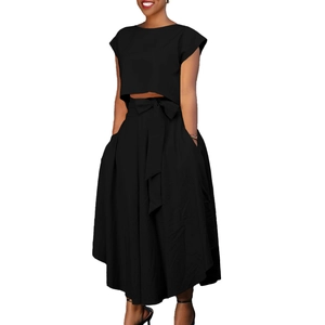 Detail of high-waist maxi skirt with side pockets and a decorative bow tie waist