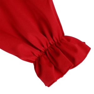 Détail de la robe rouge avec poignets à volants élastiques et tissu texturé premium