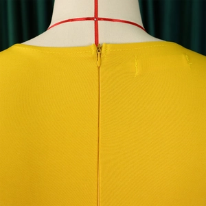 Detail of the bright yellow dress showing the invisible back zipper and fine neckline stitching