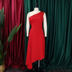 Detail of red one-shoulder dress showing side pleated waist and asymmetrical hemline