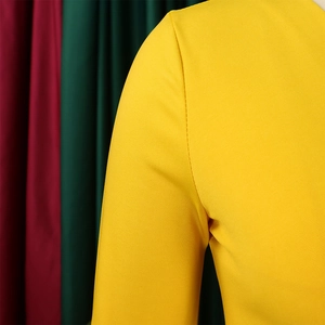 Detailed macro shot of bright yellow fabric texture and fine stitching on V-neck dress