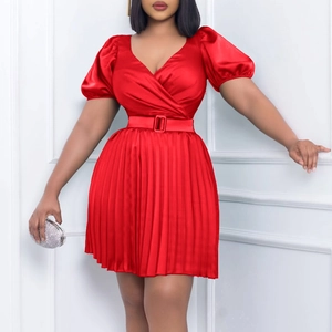 Detail view of red satin V-neck dress featuring puff sleeves and pleated skirt with belt