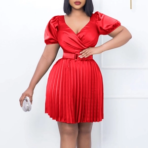 Detail of red satin V-neck dress showing fine pleats and a matching square buckle belt