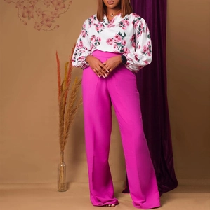 Détail d'un chemisier à imprimé floral et d'un pantalon large taille haute rose magenta