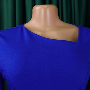 Detail of royal blue asymmetric neckline and high-quality knit fabric on dress