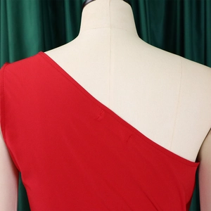 Detailed close-up of a red one-shoulder dress showing high-quality stitching and fabric texture