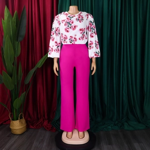 Détail de la chemise fleurie en mousseline et du pantalon large rose vif à taille haute