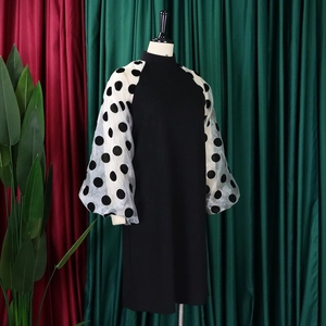 Detail eines schwarzen Kleides mit transparenten weißen gepunkteten Puffärmeln auf einer Puppe