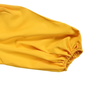 Dettaglio macro del polsino giallo a lanterna con arricciatura elastica e cuciture piatte
