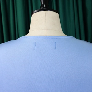 Close-up of light blue knit top neckline with detailed stitching and ribbed trim