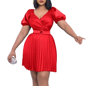 Detail of red V-neck pleated mini dress with satin finish and matching buckle belt