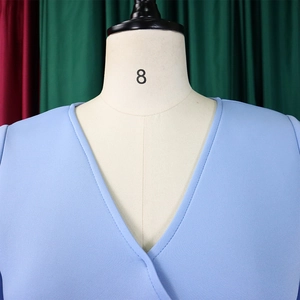 Detail of light blue cross V-neck dress showing fine fabric texture and stitching quality