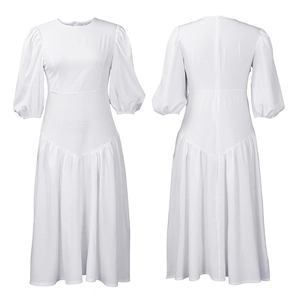 Dettaglio del vestito bianco con maniche a sbuffo, vita alta e cuciture a V