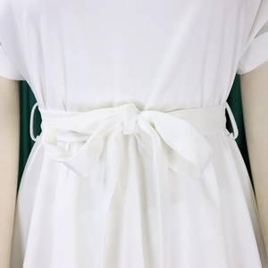 Détail de la taille d'un ensemble d'été blanc avec ceinture à nœud et tissu tissé