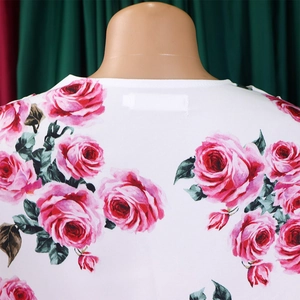 Détail de l'encolure ronde sur haut blanc avec imprimés roses roses sur un mannequin