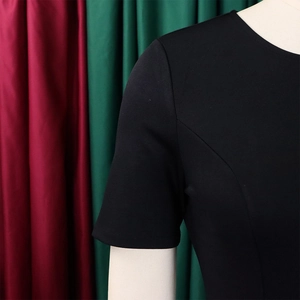 Detailansicht eines schwarzen Kurzarmkleids mit Prinzessnähten und klassischem Rundhalsausschnitt