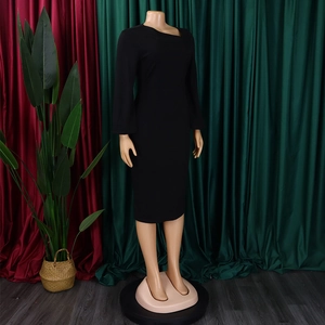Detail of elegant black long sleeve dress with unique asymmetric neckline and slim fit