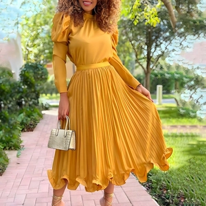 Detail of mustard yellow puff sleeve top and high waist pleated maxi skirt set
