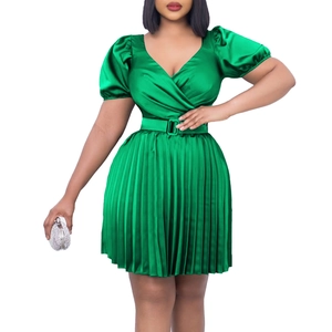 Close-up of green satin dress featuring pleated skirt with V-neck and puff sleeves