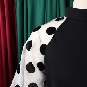 Detailansicht des Kleides mit weißen Organza-Ärmeln und schwarzen beflockten Polka Dots