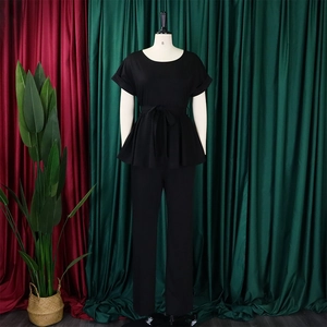 Détail de l'ensemble noir deux pièces avec haut à basque noué et pantalon large chic