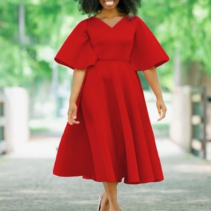 Detail of red V-neck dress with flare sleeves and elegant A-line skirt in outdoor light