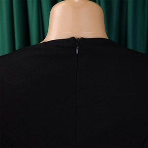 Detail view of the hidden back zipper on a black one-shoulder dress with textured fabric