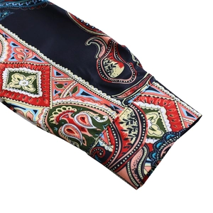 Dettaglio dei polsini con stampa paisley bohémien e cuciture di qualità su abito blu notte